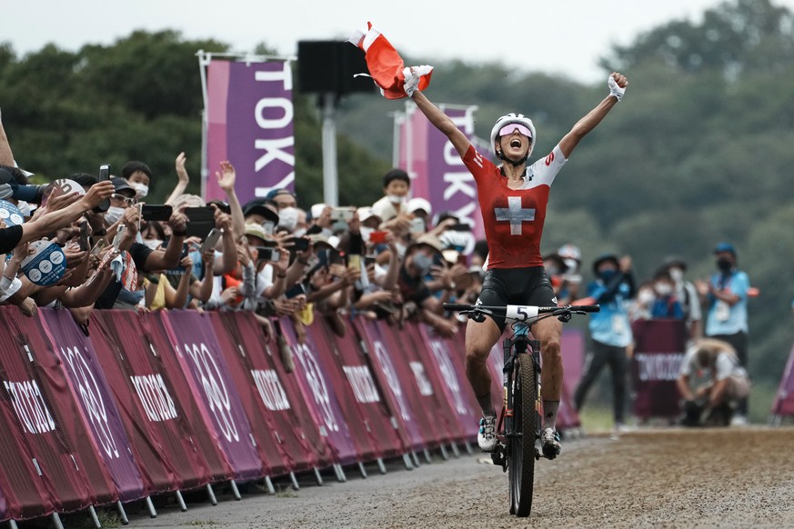 Jolanda Neff of Switzerland celebrates as she approaches the finish line to win the gold medal during the women&#039;s cross-country mountain bike competition at the 2020 Summer Olympics, Tuesday, Jul ...