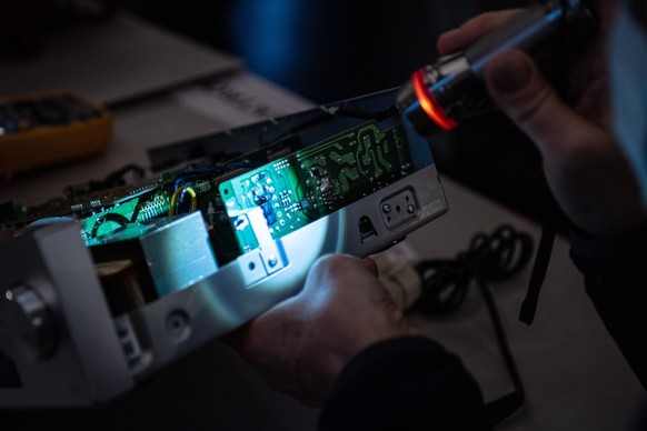 &quot;Reparaturprofi&quot; Thomas Kallweit kontrolliert eine Printplatte im Repair Cafe, am Samstag, 29. Januar 2022, in Herzogenbuchsee. Fachspezialisten reparieren unentgeltlich Elektrogeraete und a ...