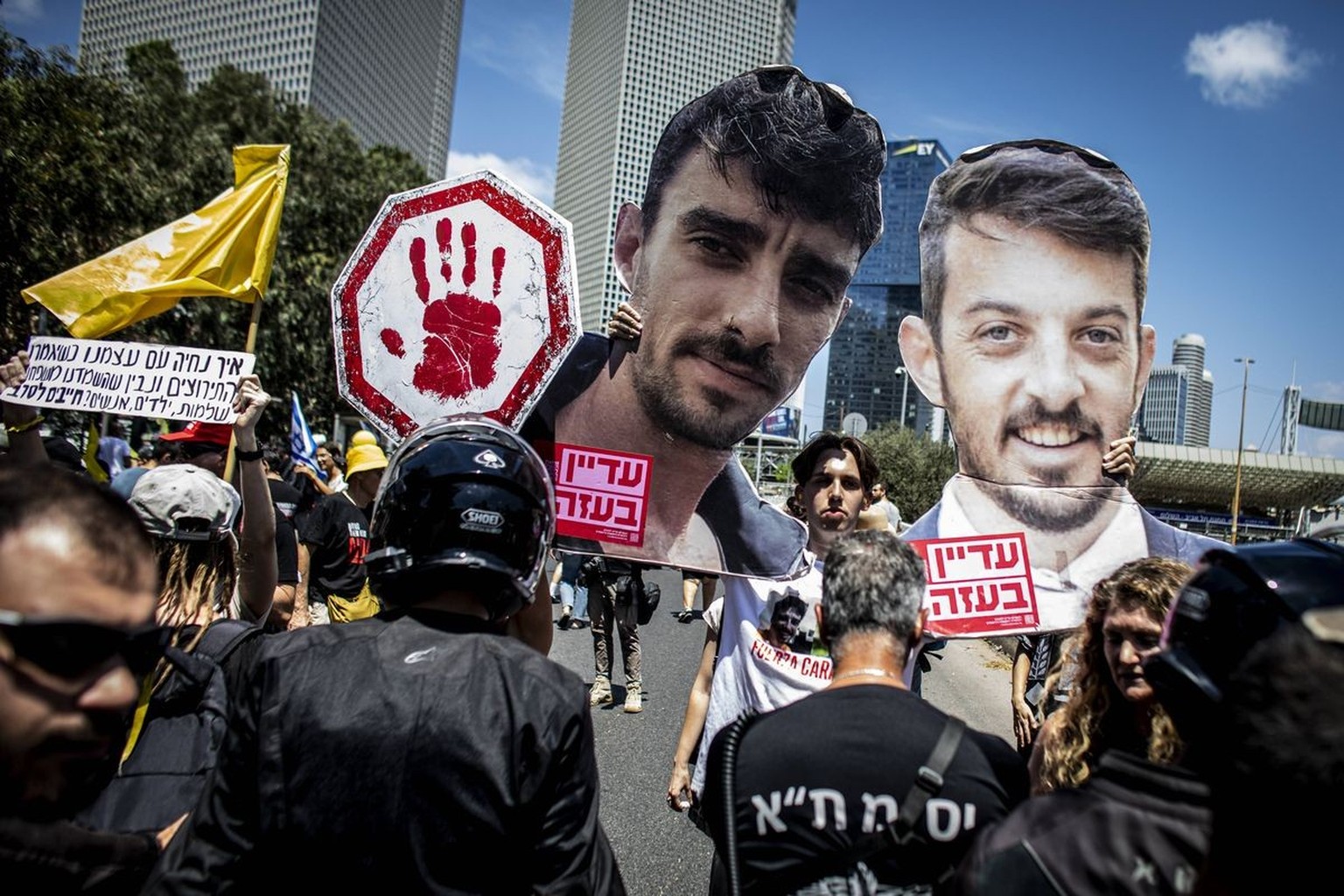 Israel nationwide protests and a general strike An Israeli protestor holds up cardboard cuttings of Ariel, L, And David, Cunio during a demonstration in Tel Aviv, Sunday Aug 17 2025, calling on Israel ...