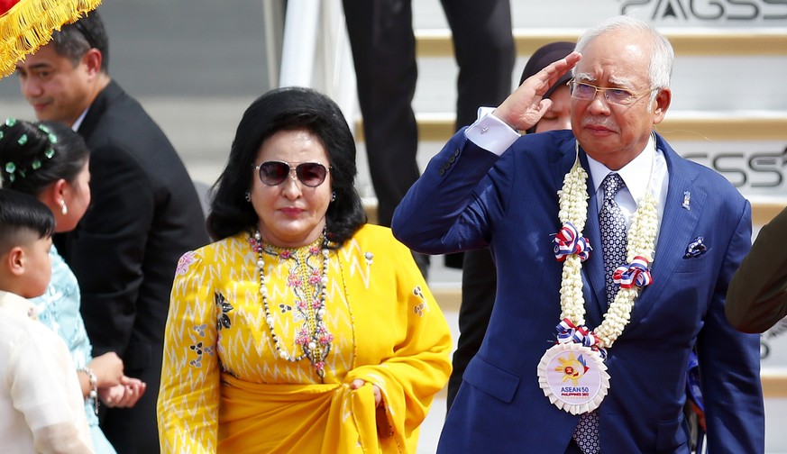 Malaysian Prime Minister Najib Razak, right, salutes the troops as he arrives with his wife Rosmah Mansor at Clark International Airport in Clark, Pampanga province, north of Manila, Philippines Sunda ...