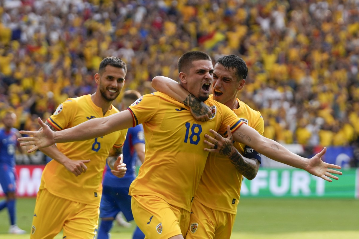 Romania's Razvan Marin, front, celebrates after scoring his side's first goal against Slovakia during a Group E match at the Euro 2024 soccer tournament in Frankfurt, Germany, Wednesday, Jun ...