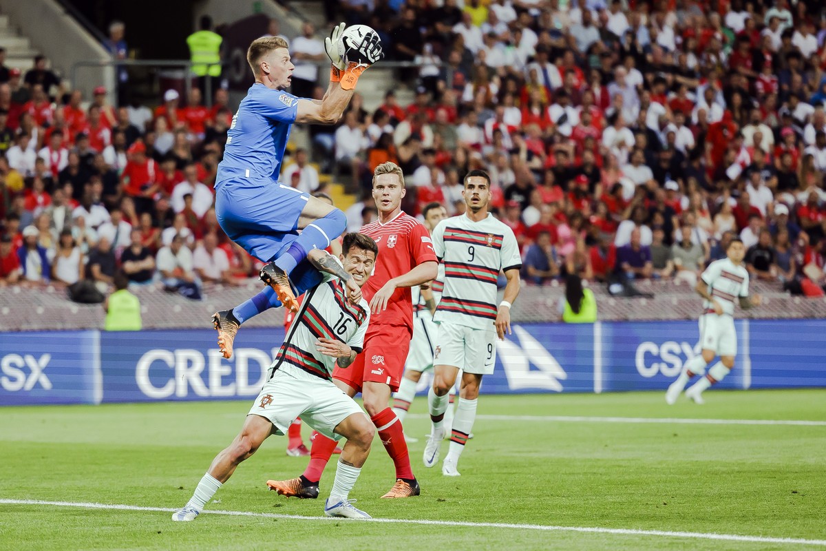 Switzerland's goalkeeper Jonas Omlin, left, makes a save against Portugal's midfielder Otavio, center, during the UEFA Nations League group A2 soccer match between Switzerland and Portugal a ...