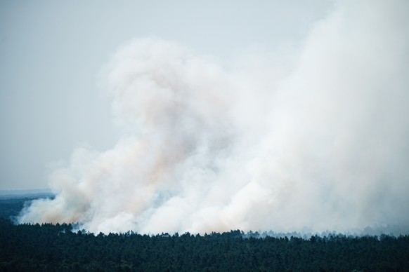 epa10105416 Smoke rises from a forest fire at the Grunewald in Berlin, Germany, 04 August 2022. The Berlin Fire Department reported on their twitter channel about a currently ongoing fire in Grunewald ...