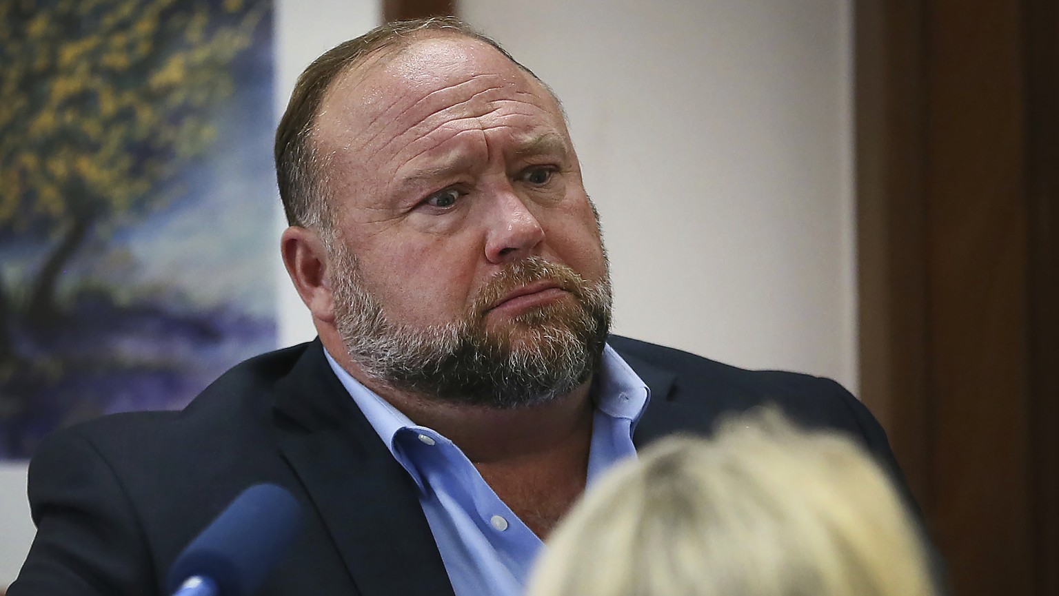 FILE - In this Aug 3, 2022 file photo, conspiracy theorist Alex Jones attempts to answer questions about his emails during trial at the Travis County Courthouse in Austin. An attorney representing two ...