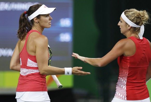 Martina Hingis, of Switzerland, left, slaps hands with her partner Timea Bacsinszky after winning a point at the 2016 Summer Olympics in Rio de Janeiro, Brazil, Saturday, Aug. 6, 2016. (AP Photo/Charl ...