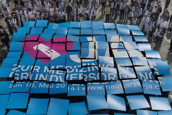 Hausaerztinnen und Hausaerzte werben mit einer Plakataktion fuer die Hausarztmedizin am Dienstag, 1. April 2014 auf dem Bundesplatz in Bern. Die Volksabstimmung ueber den &quot;Bundesbeschluss ueber d ...