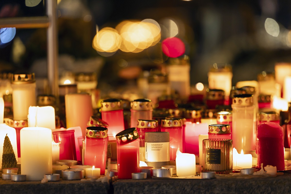 epa12629314 Lit candles in tribute to the victims of the deadly fire at the 'Le Constellation' bar in Crans-Montana, Switzerland, 05 January 2026. At least 40 people lost their lives and ove ...