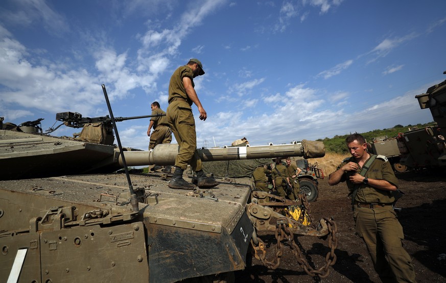 epa10305560 Israeli soldiers stand next to tanks and APCs ahead of a large Armored Corps exercise that will take place in the Israeli-annexed Golan Heights, near the border with Syria, 14 November 202 ...