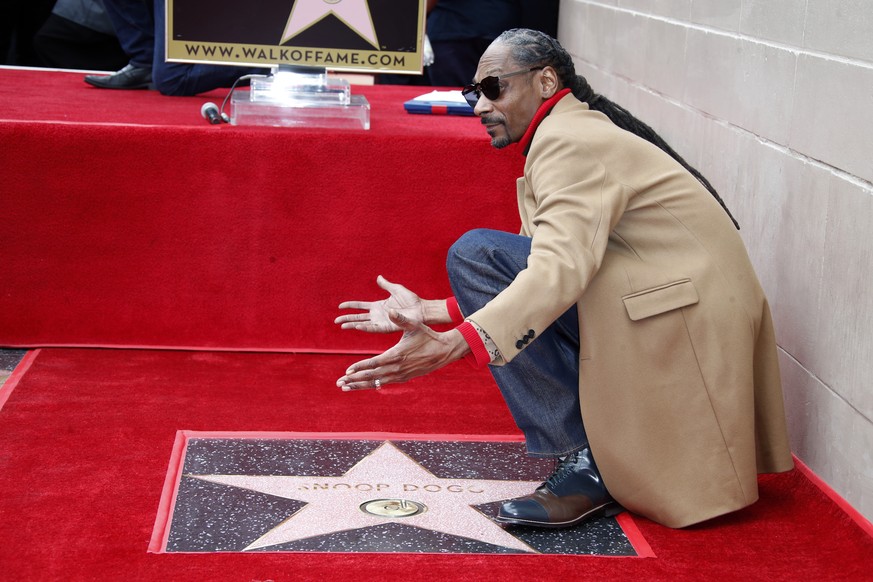 epa07178275 US musician Snoop Dogg poses on his star during a ceremony honoring him on the Hollywood Walk of Fame in Hollywood, California, USA, 19 November 2018. Snoop Dogg received the 2,651st star  ...