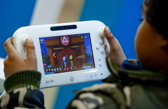 epa04046373 (FILE) A file photo dated 30 November 2012 shows a young gamer trying out a Wii U console at a Mediamarkt store in Utrecht, The Netherlands. Japanese gaming giant Nintendo Co. said 29 Janu ...