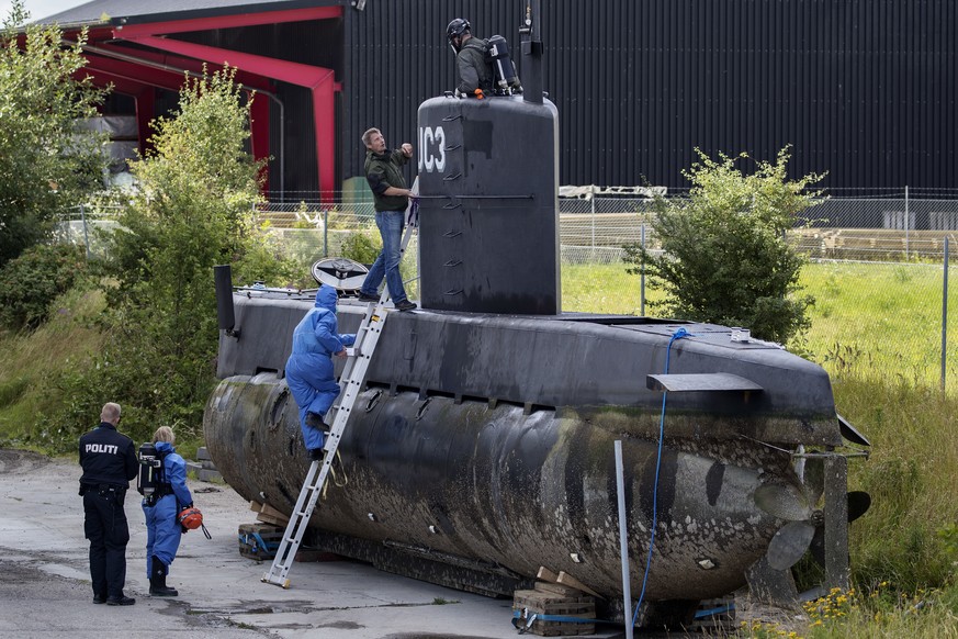 Police technicians board the amateur -built submarine UC3 Nautilus on a pier in Copenhagen harbour, Denmark, Sunday, Aug. 13, 2017, to conduct forensic probes in connection with a murder investigation ...