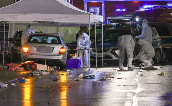 epaselect epa08244696 Forensic experts investigate next to a silver-colored Mercedes car that crashed into a group of revelers during the Rose Monday carnival parade in Volkmarsen near Kassel, Germany ...