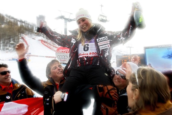 Lara Gut from Switzerland, 2nd placed, and her coach Mauro Pini, left, celebrate with champagne, after the women&#039;s Downhill, at the World Alpine Ski Championships in Val d&#039;Isere, France, Mon ...