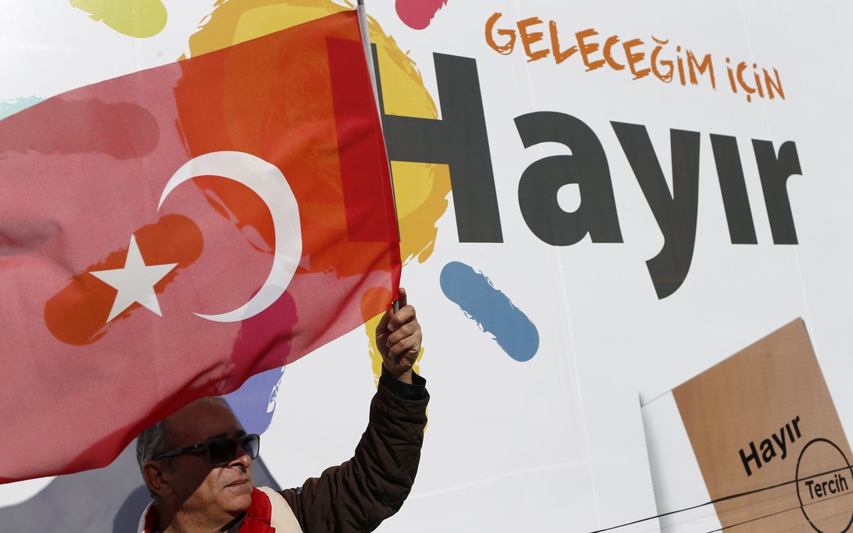 epa05856093 A member of the Republican People's Party (CHP) standing with a Turkish flag in front of the giant billboard reading , 'For my future, NO', at Eminonu Square in Istanbul, Tu ...