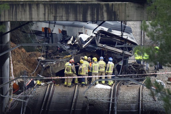 epa12667596 Rescuers inspect a commuter train that derailed between Gelida and Sant Sadurni d'Anoia, Barcelona, Spain, 21 January 2026. The train driver has died and 37 passengers were injured, f ...