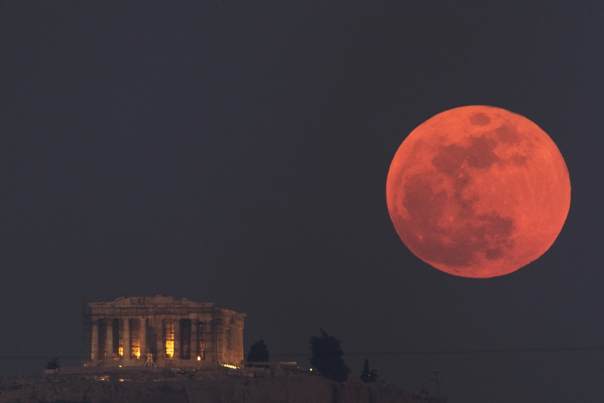 A super blue blood moon rises behind the 2,500-year-old Parthenon temple on the Acropolis of Athens, Greece, on Wednesday, Jan. 31, 2018. On Wednesday, much of the world will get to see not only a blu ...