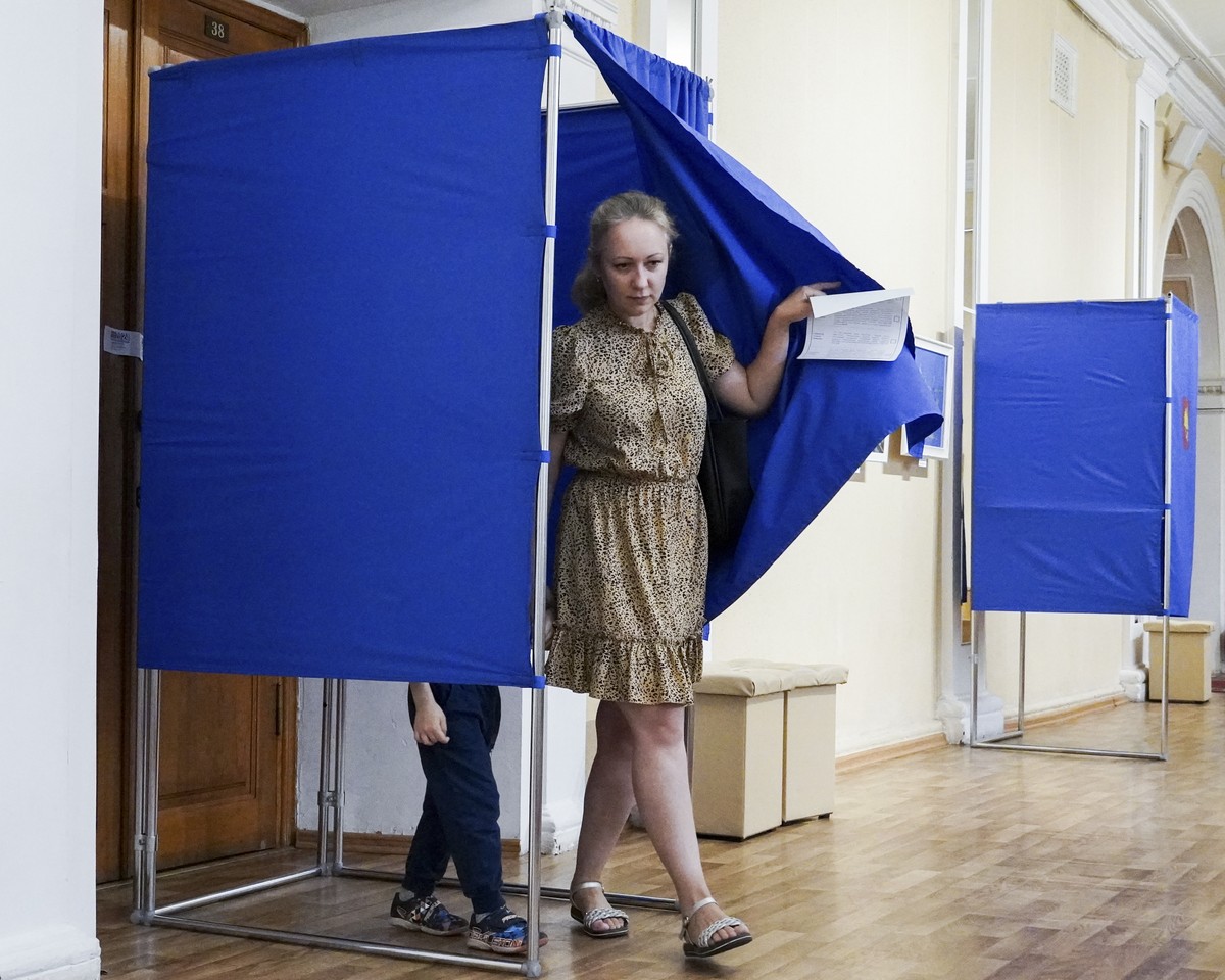 epaselect epa11593063 A woman leaves the voting booth after casting her ballot to elect the new Kursk regional governor during the single election day, at a polling station in Kursk, Russia, 08 Septem ...