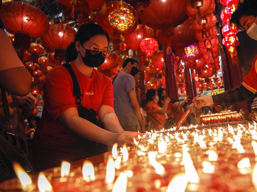 epa10422202 People burn candles to welcome the Chinese Lunar New Year at a Chinese Buddhist temple in Chinatown, Bangkok, Thailand, 22 January 2023. The Chinese lunar new year, or Spring Festival as i ...