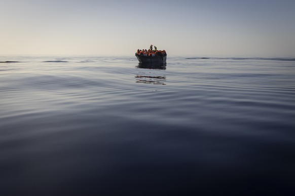 FILE - Migrants with life jackets provided by volunteers of the Ocean Viking, a migrant search and rescue ship run by NGOs SOS Mediterranee and the International Federation of Red Cross (IFCR), still  ...