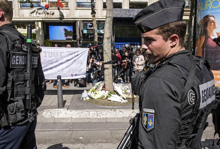 epa05919251 French Gendarmerie officers pay tribute to the French policeman killed at the Champs Elysee avenue in Paris, France, 21 April 2017. A police officer the previous day was killed along with  ...