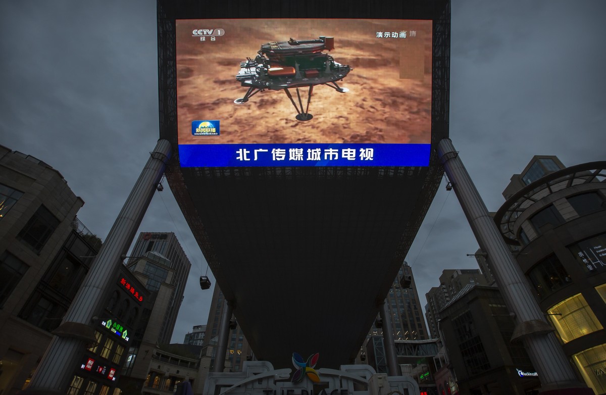 A Chinese state media broadcast of a news report about the country's successful landing of a probe on Mars is shown on a large video screen at a shopping mall in Beijing, Saturday, May 15, 2021.  ...