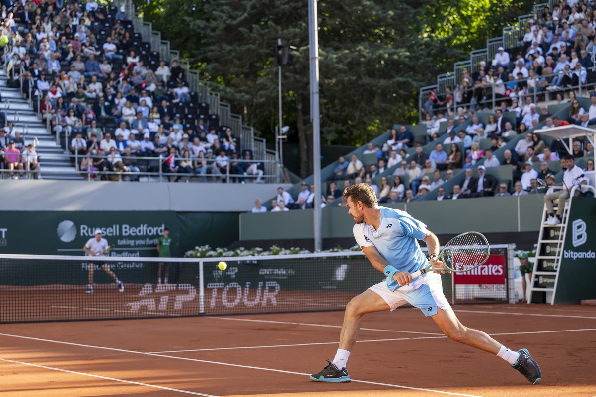 epa12978792 Stan Wawrinka from Switzerland (R) in action against Alex Michelsen (rear) from the United States during their men's singles round of 16 match at the Geneva Open tennis tournament in  ...