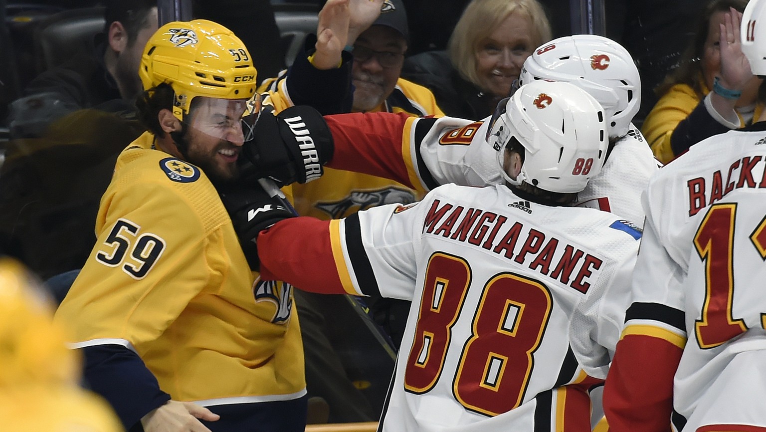 Nashville Predators defenseman Roman Josi (59), of Switzerland, fights with Calgary Flames&#039; Matthew Tkachuk (19) and Andrew Mangiapane (88) during the second period of an NHL hockey game Thursday ...