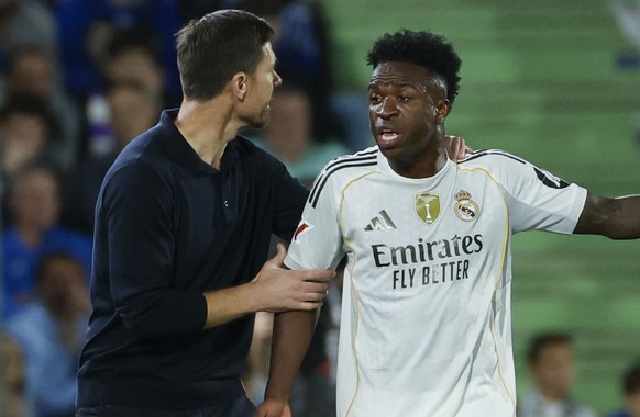 epa12465850 Real Madrid's head coach Xavi Alonso interacts with his player Vinicius Junior (R) during the Spanish LaLiga soccer match between Getafe CF and Real Madrid in Getafe, Spain, 19 Octobe ...