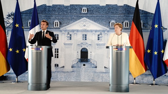 epa08516545 German Chancellor Angela Merkel (R) and French President Emmanuel Macron address a press conference after their meeting at the German government&#039;s guest house Meseberg Castle in Grans ...