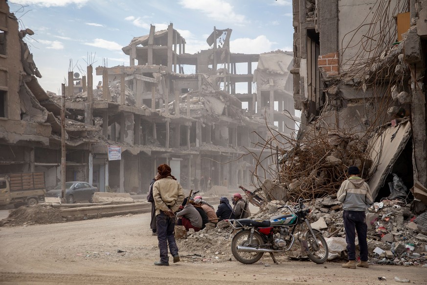 Männer warten an einer Strasse in Raqqa auf Arbeit.