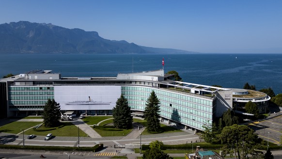 epa11562646 A drone picture shows workers hanging a giant photograph titled &#039;Belle epoque&#039; by Swiss artist Vincent Jendly, showing the &#039;La Suisse&#039; steam boat, on the facade of the  ...