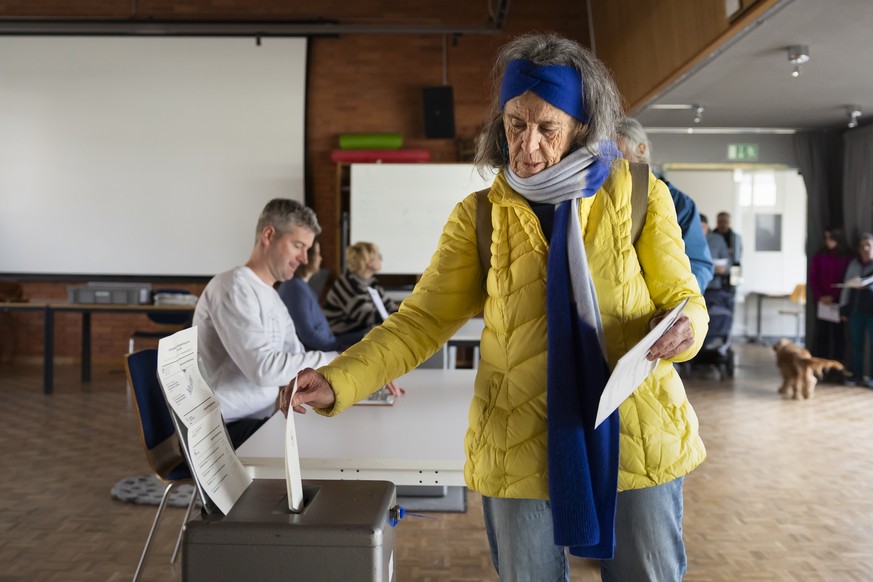 Eine Stimmbuergerin wirft ihren Stimmzettel in die Urne, im Stimmlokal Schulhaus Hochfeld, am Samstag, 2. Maerz 2024 in Bern. Die Schweizer Buergerinnen und Buerger stimmen ueber die Renteninitiative  ...