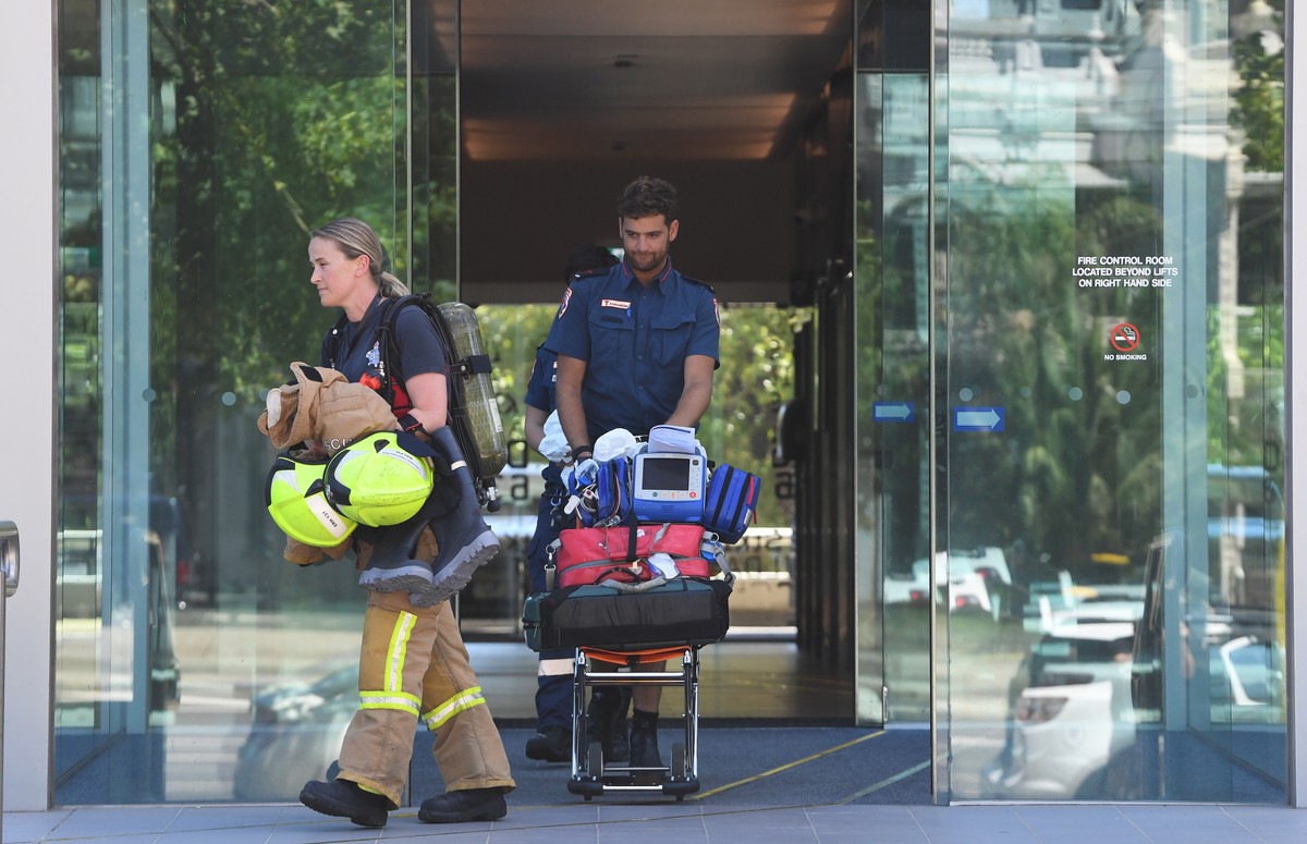 epa07270517 Emergency service personel exit the building where the Korean consulate is located in Melbourne, Australia, 09 January 2019. Staff have been evacuated as emergency crews respond to a numbe ...
