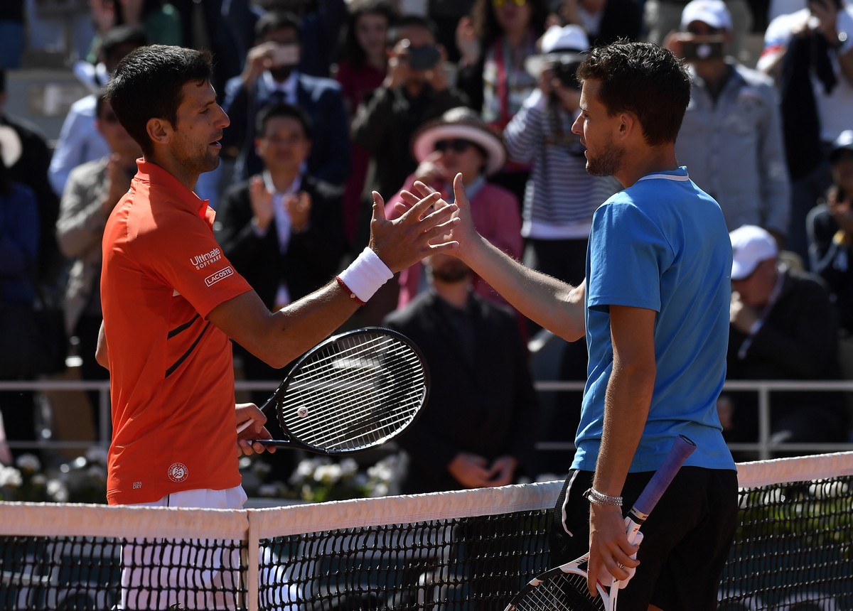 epa07634946 Dominic Thiem of Austria (R) reacts with Novak Djokovic of Serbia after winning their men’s semi final match during the French Open tennis tournament at Roland Garros in Paris, France, 08  ...