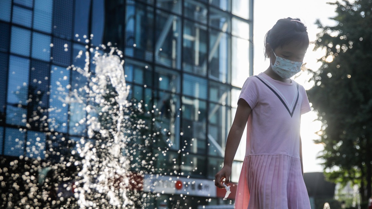 epa10113999 A girl wearing a face mask walks beside a shopping mall in Beijing, China, 10 August, 2022. Chinese authorities have closed Tibet's Potala Palace after COVID-19 cases were detected in ...