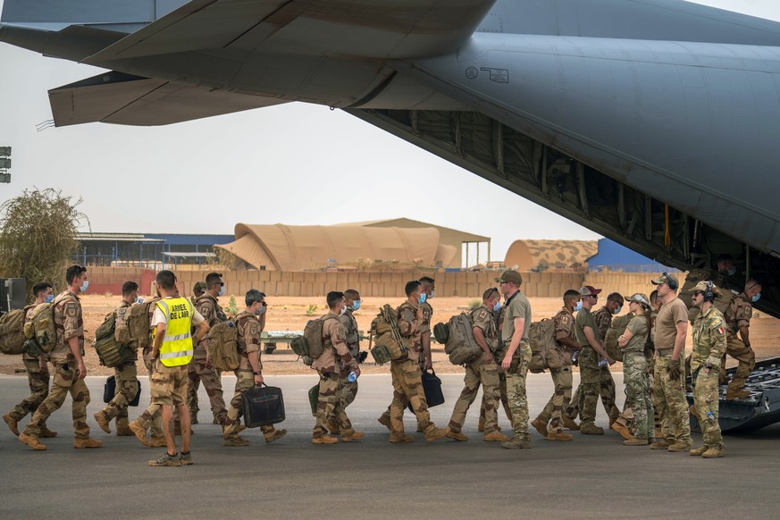 FILE - French Barkhane force soldiers who wrapped up a four-month tour of duty in the Sahel leave their base on a US Air Force C130 transport plane in Gao, Mali, June 9, 2021. French President Emmanue ...