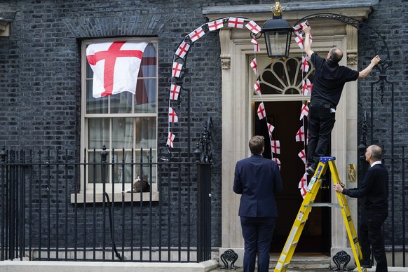 England flag bunting decorations are removed from outside 10 Downing Street, in London, Monday, July 12, 2021, after Italy beat England to win the Euro 2020 soccer championship, in a final played at W ...