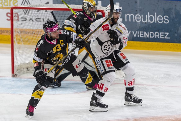 Ajoies Jordane Hauert, links, gegen Luganos Giovanni Morini, rechts, beim Eishockey-Qualifikationsspiel der National League zwischen dem HC Ajoie und dem HC Lugano in der Raiffeisen Arena in Porrentru ...