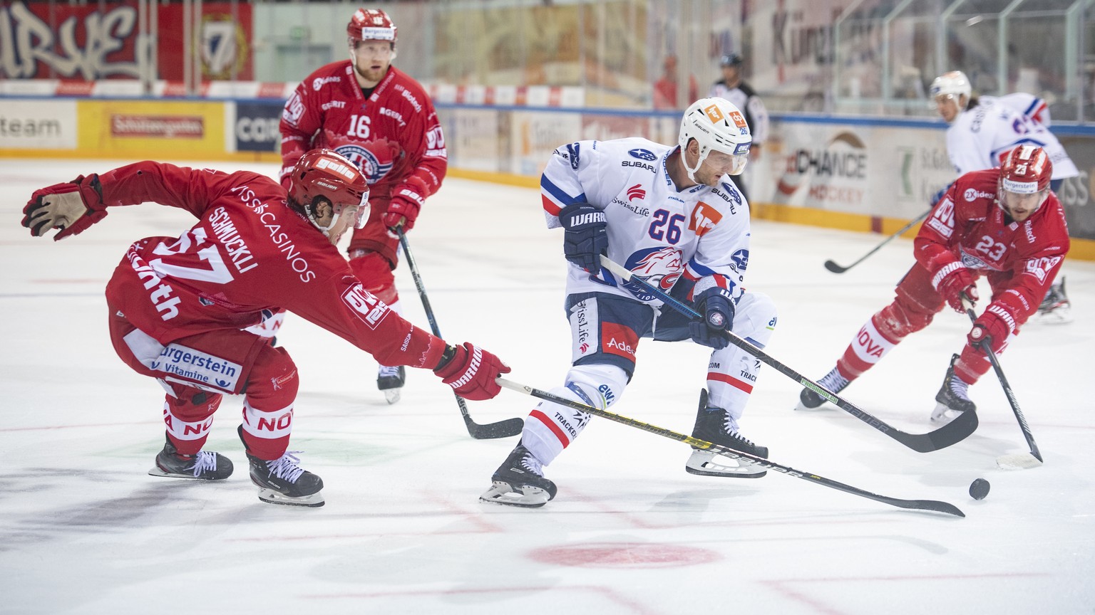 Zuerichs Simon Bodenmann, Mitte, kaempft um den Puck gegen Rapperswils Florian Schmuckli, links, und Nico Duenner, rechts, im Eishockeyspiel der National League zwischen den Rapperswil-Jona Lakers und ...