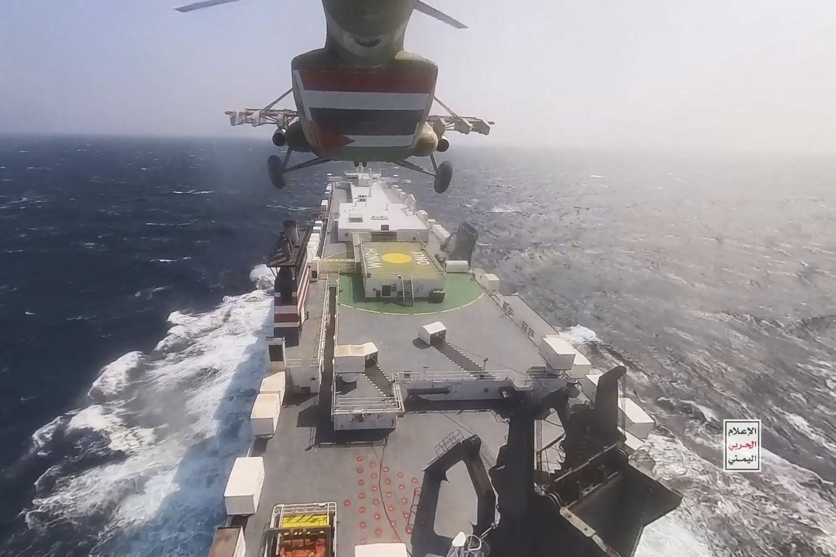 This photo released by the Houthi Media Center shows a Houthi forces helicopter approaching the cargo ship Galaxy Leader on Sunday, Nov. 19, 2023. Yemen's Houthis have seized the ship in the Red  ...