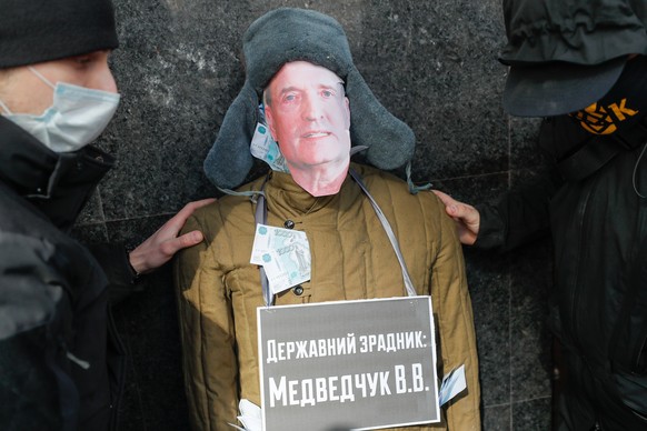 epa09095982 Activists of the National Corps party hold effigy depicturing Viktor Medvedchuk with a placard reading &#039;State betrayer&#039; during their rally demanding to release the report of the  ...