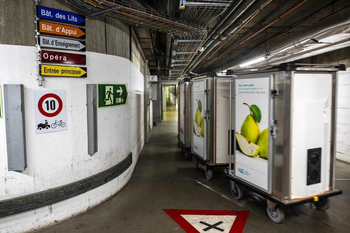 Un membre du personnel des HUG transporte des chariots repas a l'aide d'un vehicule electrique dans l'un des tunnels souterrains des Hopitaux Universitaires de Geneve (HUG) reliant les  ...