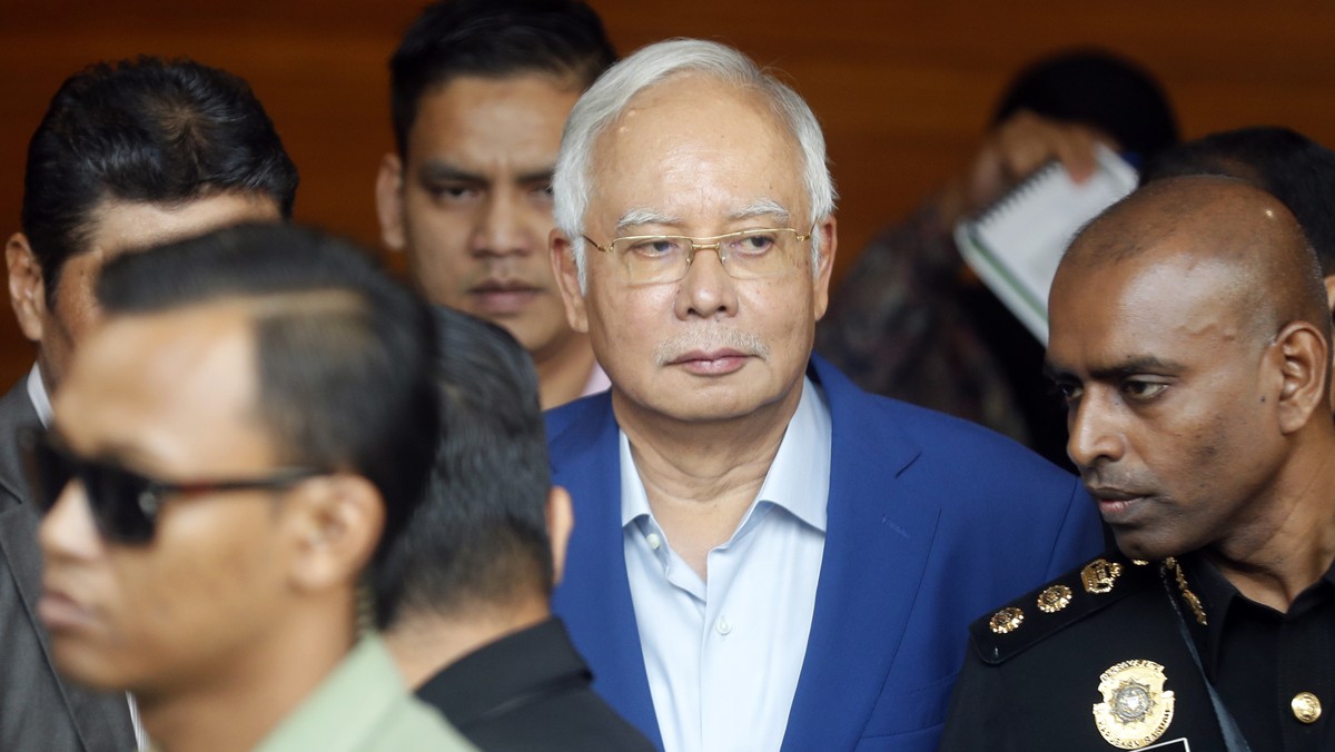 In this May 22, 2018, file photo, former Malaysian Prime Minister Najib Razak, center, arrives at Anti-Corruption Agency for questioning in Putrajaya, Malaysia. Malaysia's anti-graft agency says  ...