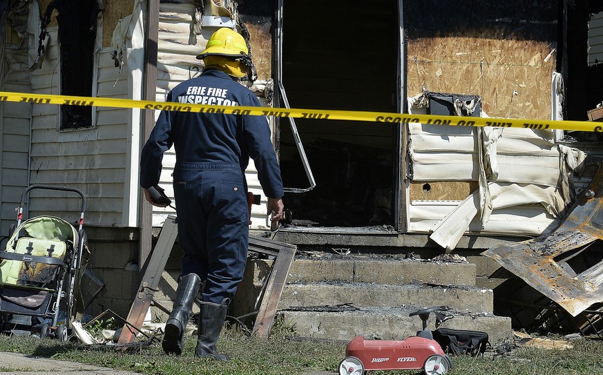 Erie Bureau of Fire Inspector Mark Polanski helps investigate a fatal fire at 1248 West 11th St. in Erie, Pa, on Sunday, Aug. 11, 2019. Authorities say an early morning fire in northwestern Pennsylvan ...