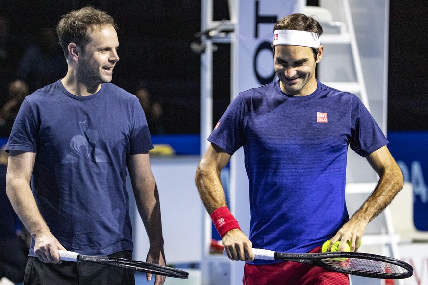 Roger Federer of Switzerland, right, talks to coach Severin Luethi, left, during a training session for the Swiss Indoors tennis tournament at the St. Jakobshalle in Basel, Switzerland, on Friday, Oct ...