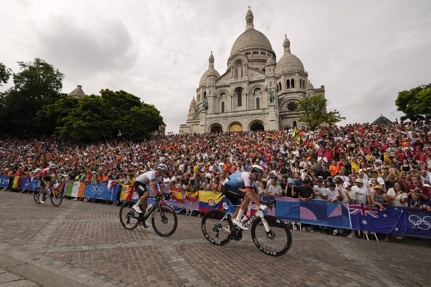 Derek Gee, of Canada, right, leads Magnus Sheffield, of the United States, as they ride past the Sacre Coeur basilica, during the men&#039;s road cycling event, at the 2024 Summer Olympics, Saturday,  ...