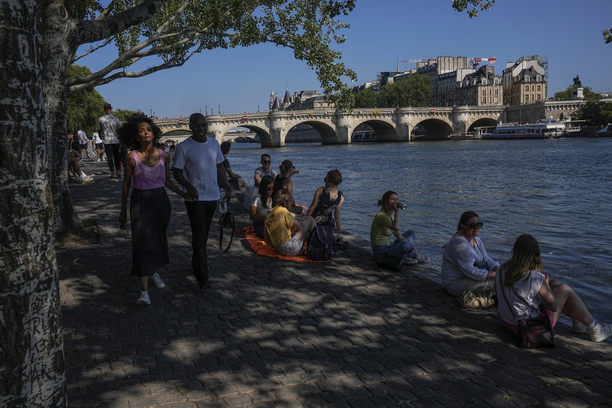 People sit in the shade along the Seine river in Paris, Sunday, June 25, 2023. Temperatures in Paris rose to 34 degrees celsius (93.2 Fahrenheit) on Sunday. (AP Photo/Michel Euler)