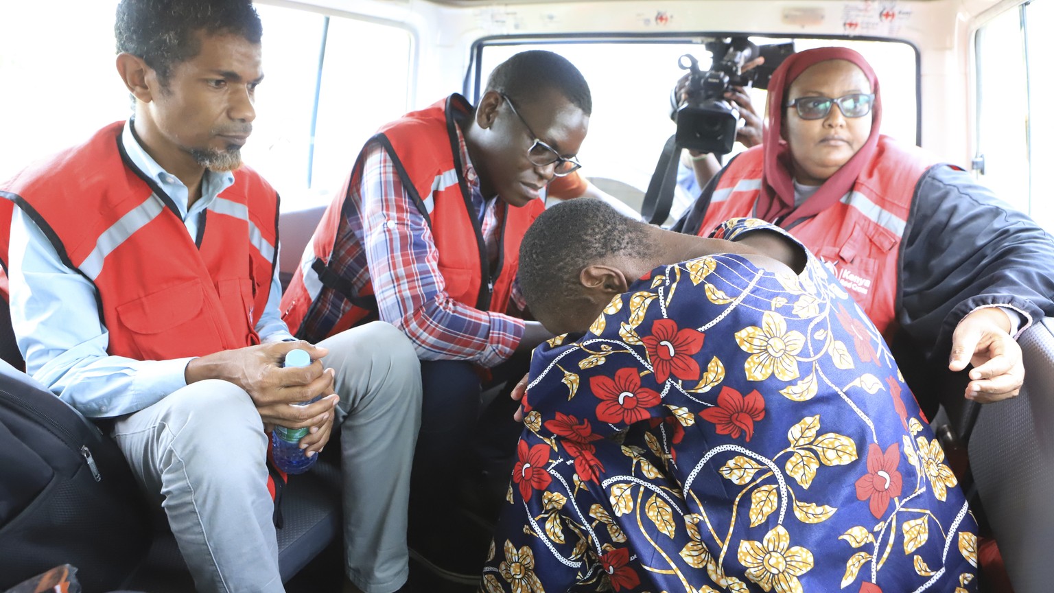 A woman, one of the followers of a Christian Cult that has killed dozens bends as she sits next to Kenya Red Cross officials inside a car after being rescued by police in a forest in Shakahola, outski ...