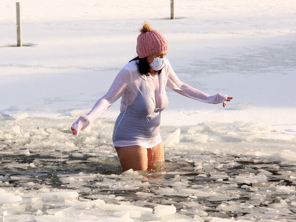 31.01.2021, Sachsen-Anhalt, Hasselfelde: Zwei Frauen baden im eisigen Wasser im Waldseebad. Seit sechs Jahren treffen sich die Frauen und M
