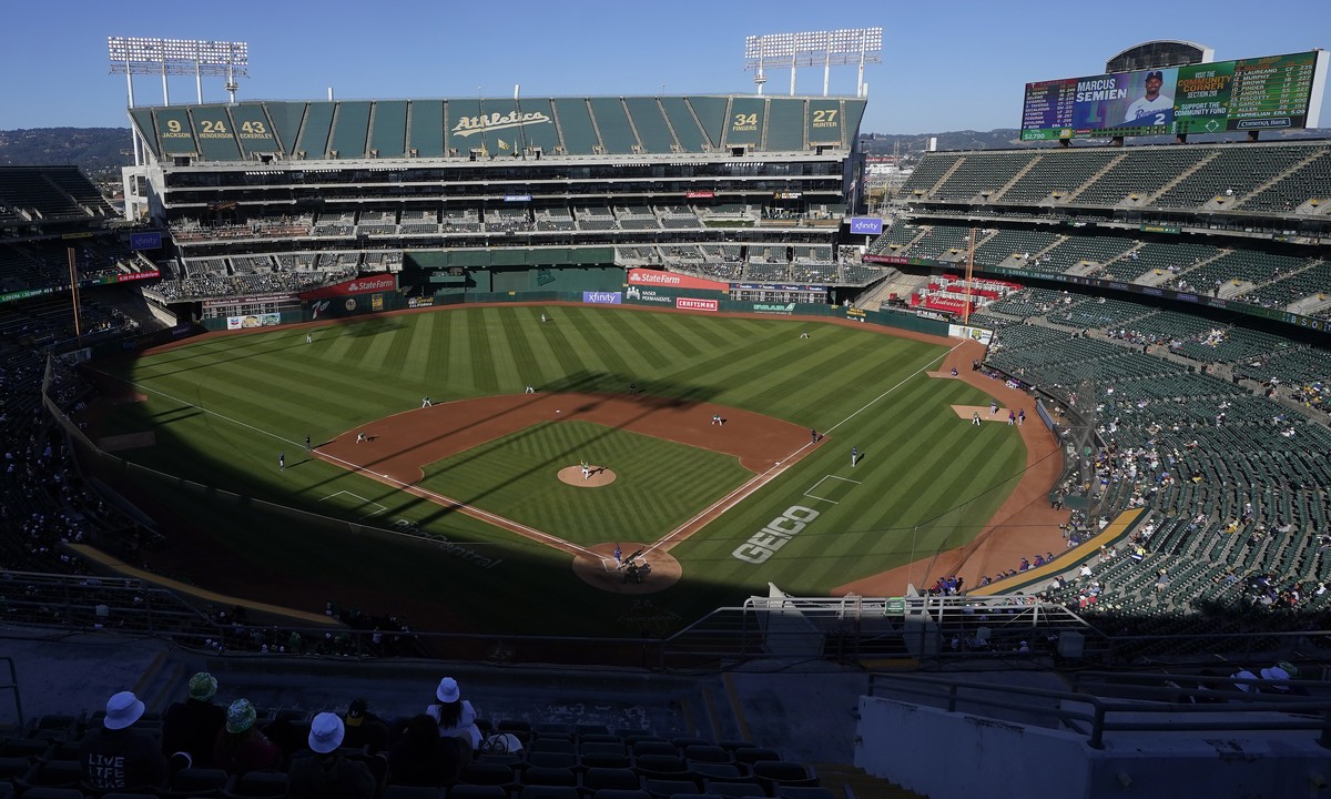 FILE - People watch a baseball game at Oakland Coliseum between the Oakland Athletics and the Texas Rangers in Oakland, Calif., July 23, 2022. The Athletics have signed a binding agreement to purchase ...